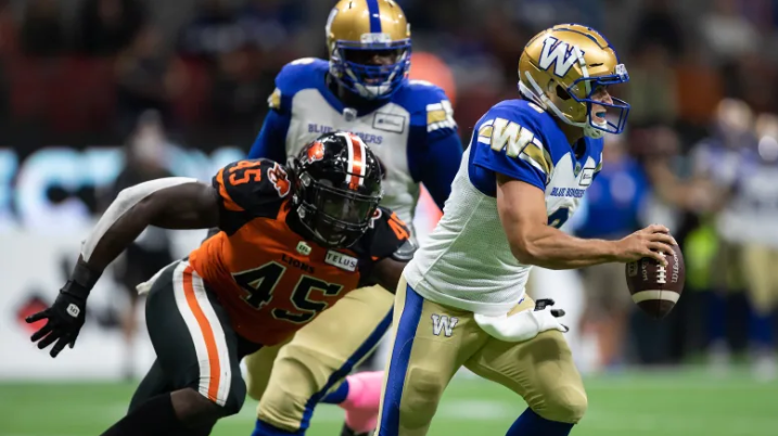 Winnipeg quarterback Zach Collaros, right, gets away from B.C.'s Tim Bonner during the first half of the Blue Bombers' 30-9 win over the Lions on Friday. (Darryl Dyck/The Canadian Press)
