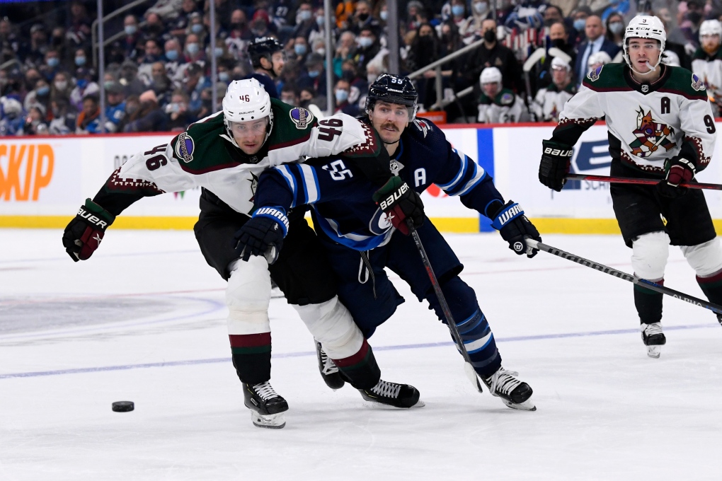 Winnipeg Jets' Mark Scheifele (55) and Arizona Coyotes' Ilya Lyubushkin (46) battle for the puck during the second period of NHL action in Winnipeg, Monday, Nov. 29, 2021. THE CANADIAN PRESS/Fred Greenslade 