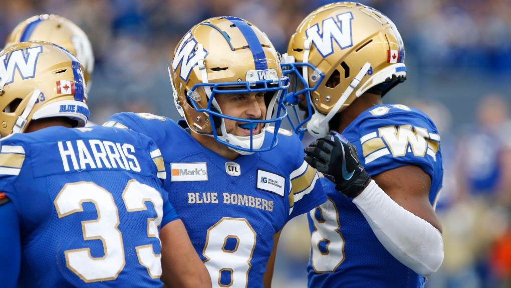 Winnipeg Blue Bombers quarterback Zach Collaros (8) celebrates his touchdown pass to Darvin Adams (1) against the Saskatchewan Roughriders during the second half of CFL action in Winnipeg Saturday, September 11, 2021.THE CANADIAN PRESS/John Woods 