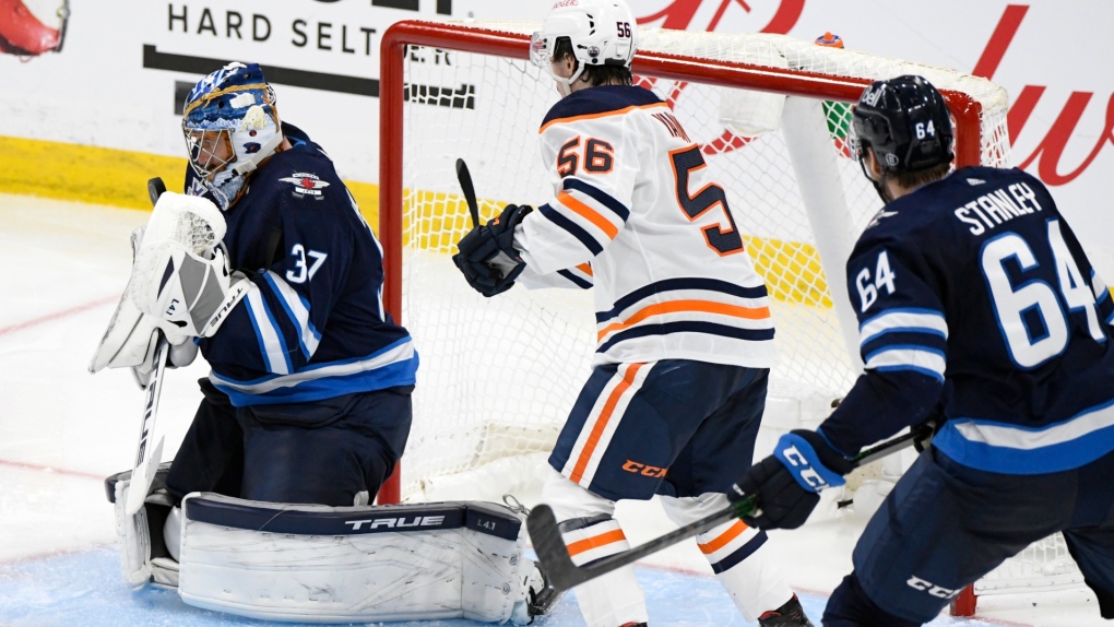 Winnipeg Jets goaltender Connor Hellebuyck (37) makes a save as Edmonton Oilers’ Kailer Yamamoto (56) looks for the rebound during third period NHL Stanley Cup playoff action in Winnipeg on Monday, May 24, 2021. (THE CANADIAN PRESS/Fred Greenslade) 