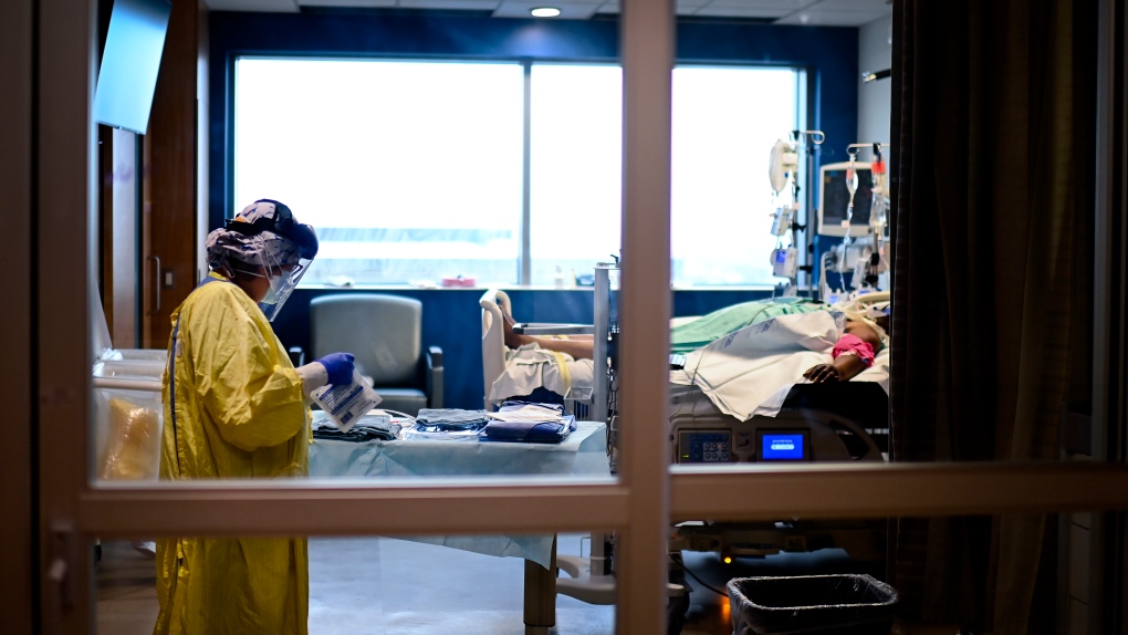 An ICU health-care worker shown inside a negative pressure room cares for a COVID-19 patient on a ventilator at the Humber River Hospital during the COVID-19 pandemic in Toronto on Wednesday, December 9, 2020. THE CANADIAN PRESS/Nathan Denette