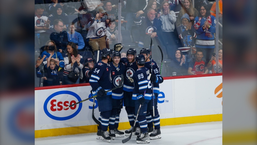 Winnipeg Jets' Dylan Samberg (54), Ville Heinola (14), Dominic Toninato (21), Sam Gagner (89) and David Gustafsson (19) celebrate a goal against the Calgary Flames during second period NHL pre-season game action in Winnipeg on Wednesday, October 5, 2022. THE CANADIAN PRESS/John Woods