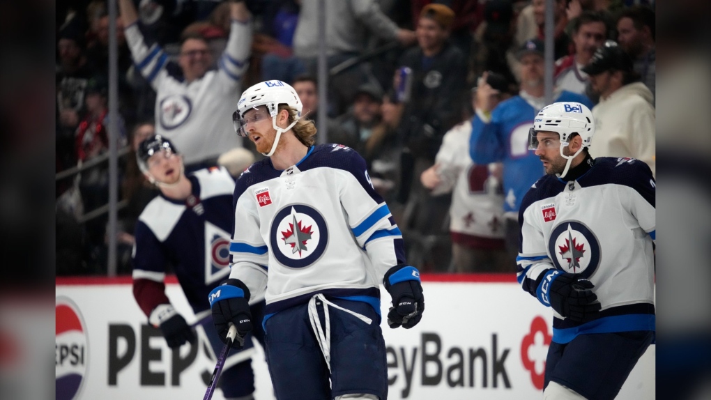 Winnipeg Jets left wing Kyle Connor, left, skates next to defenseman Dylan DeMelo after scoring an empty-net goal against the Colorado Avalanche during the third period of an NHL hockey game Thursday, Dec. 7, 2023, in Denver. (AP Photo/David Zalubowski)