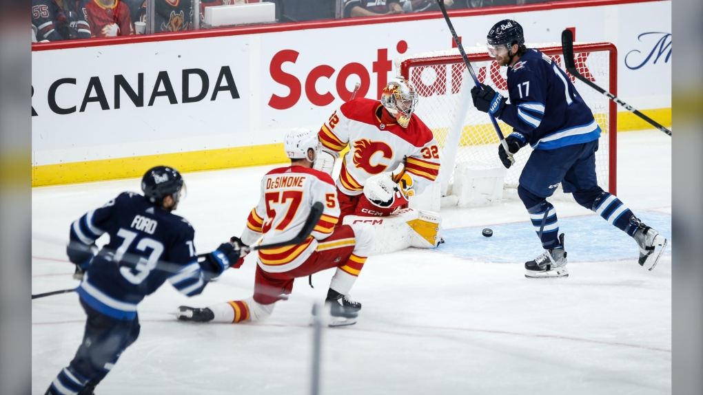 Winnipeg Jets' Parker Ford (73) scores on Calgary Flames goaltender Dustin Wolf (32) during third period NHL pre-season game action in Winnipeg, Wednesday, Sept. 27, 2023. THE CANADIAN PRESS/John Woods